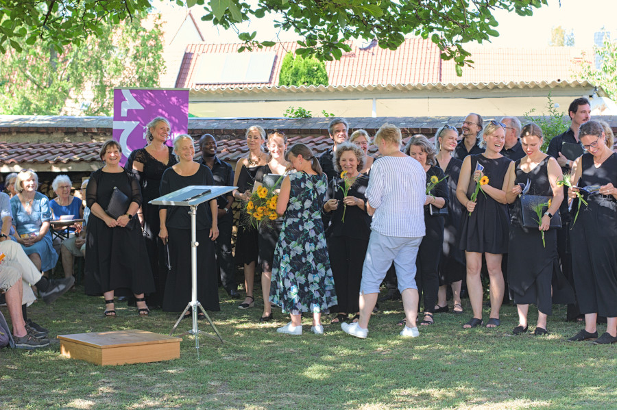 Die Sängerinnen und Sänger des Rundfunkchores bekommen eine Blume und das Libretto - Heft zur Schildbürger Kantate